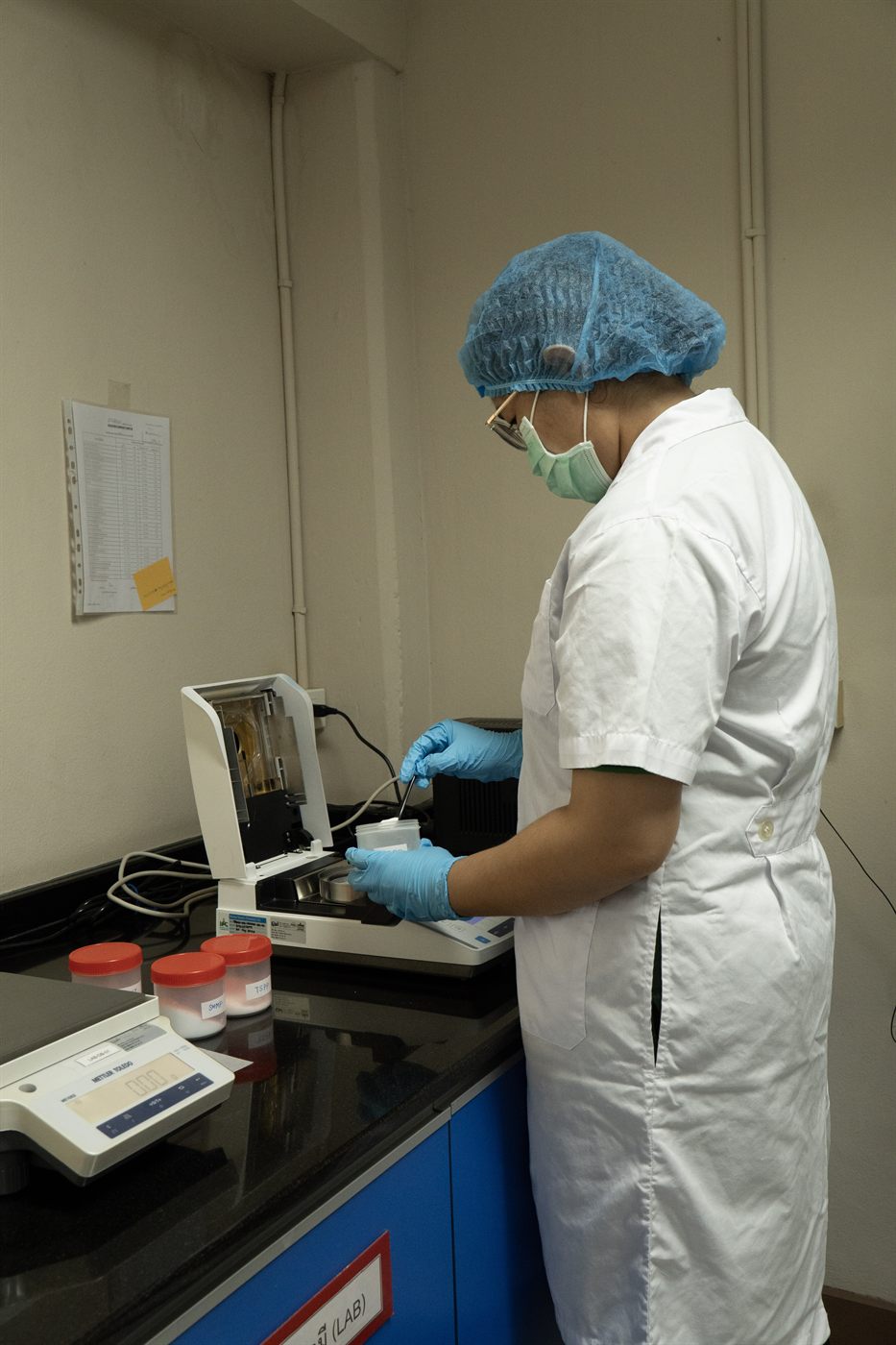 Jirakorn QA staff testing a sample with a moisture analyzer