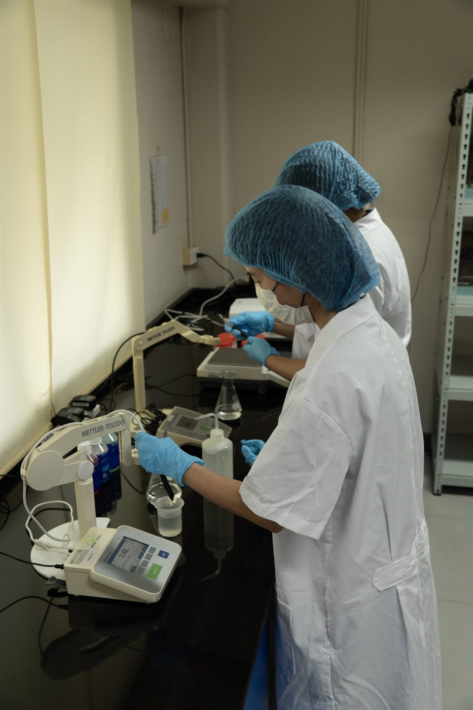 Jirakorn lab staff running pH and titration tests on a formulation